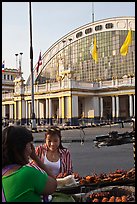 Woman buying food at stall in front of station. Bangkok, Thailand (color)