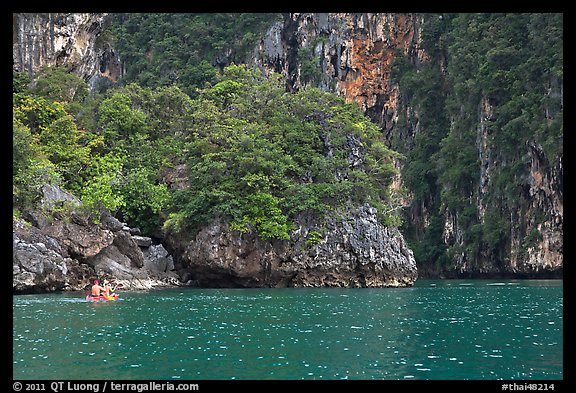 Couple paddling below steep cliffs. Krabi Province, Thailand (color)