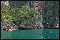 Couple paddling below steep cliffs. Krabi Province, Thailand (color)