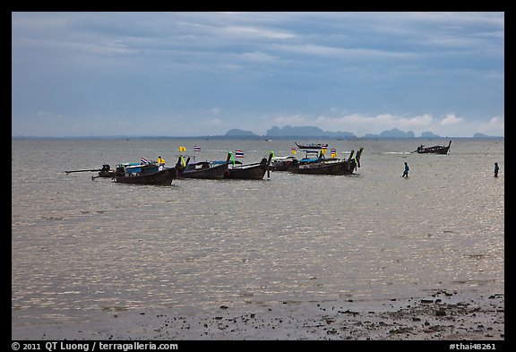 Boats anchored at low tide, storm sky,  Railay East. Krabi Province, Thailand