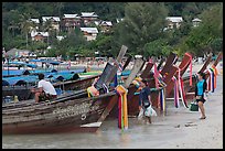 Women returning with shopping bags prepare to board boats, Ko Phi Phi. Krabi Province, Thailand (color)
