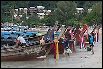 Women returning with shopping bags prepare to board boats, Ko Phi Phi. Krabi Province, Thailand