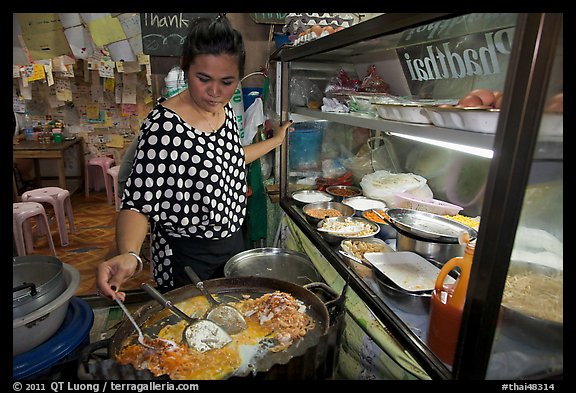 Woman adding spices to Pad Thai, Ko Phi-Phi island. Krabi Province, Thailand