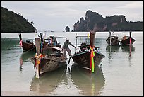 Man stepping on boats, Ao Lo Dalam, Ko Phi-Phi Don. Krabi Province, Thailand (color)