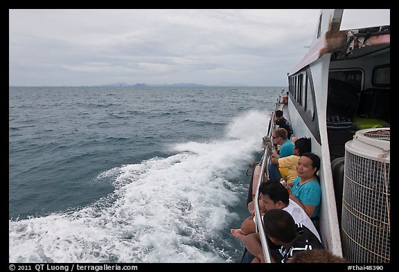 Passengers sitting on side of boat. Krabi Province, Thailand (color)