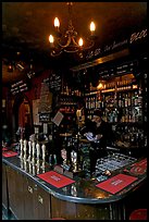 Woman cleaning glass at the bar, pub The Grenadier. London, England, United Kingdom ( color)