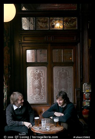 Young men, beer pints, and etched glass, pub Princess Louise. London, England, United Kingdom