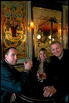 Friends cheering up with a beer in front of echted glass and fine tiles of pub Princess Louise. London, England, United Kingdom