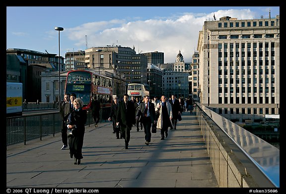 Office workers pouring out of the city of London across London Bridge, late afternoon. London, England, United Kingdom