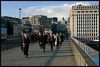 Office workers pouring out of the city of London across London Bridge, late afternoon. London, England, United Kingdom (color)