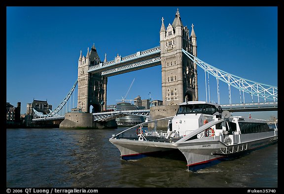 Fast catamaran cruising the Thames, with Tower Bridge in the background. London, England, United Kingdom