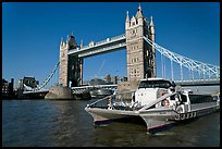 Fast catamaran cruising the Thames, with Tower Bridge in the background. London, England, United Kingdom