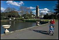 Woman pushing stroller next to the lake. Kew Royal Botanical Gardens,  London, England, United Kingdom