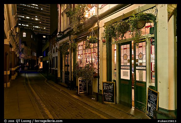 Saloon bar and cobblestone alley at night. London, England, United Kingdom