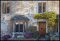 Stone house facade with flowers, Castle Combe. Wiltshire, England, United Kingdom (color)