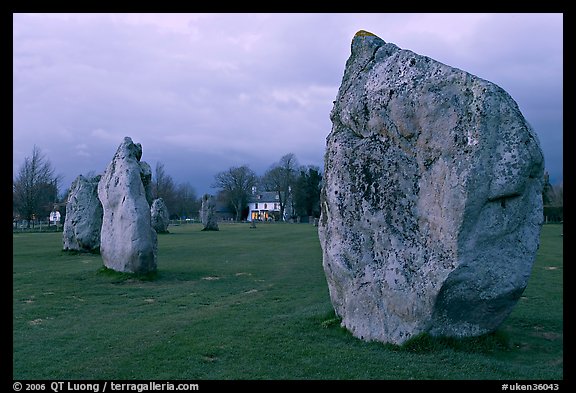 Standing stone circle and village house at dusk, Avebury, Wiltshire. England, United Kingdom (color)