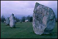 Standing stone circle and village house at dusk, Avebury, Wiltshire. England, United Kingdom