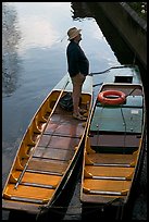 Man standing in a rowboat, old town moat. Canterbury,  Kent, England, United Kingdom