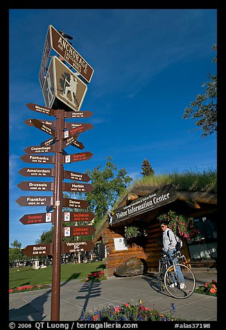 Sign Air Crossroads of the World, man on bicycle in front of visitor center. Anchorage, Alaska, USA