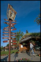 Sign Air Crossroads of the World, man on bicycle in front of visitor center. Anchorage, Alaska, USA