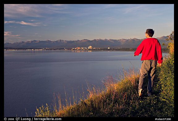 Man walking on the edge of Knik Arm in Earthquake Park, sunset. Anchorage, Alaska, USA