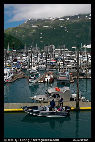 Small boat loaded at pier, harbor, and mountains. Whittier, Alaska, USA (color)