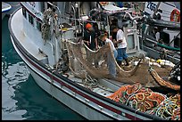 Fishermen repairing nets on fishing boat. Whittier, Alaska, USA (color)