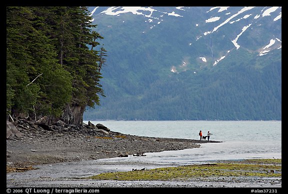 Women fishing and dog, at the edge of Passage Canal Fjord. Whittier, Alaska, USA