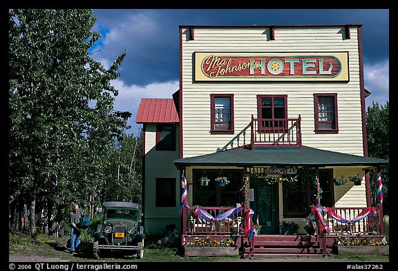 Small hotel with classic car parked by, afternoon. McCarthy, Alaska, USA (color)