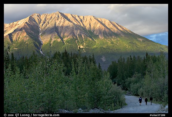 People strolling on unpaved road at sunset. McCarthy, Alaska, USA (color)