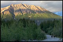 People strolling on unpaved road at sunset. McCarthy, Alaska, USA