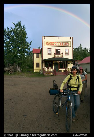 Women with bikes, hotel, and rainbow. McCarthy, Alaska, USA (color)