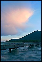 Footbridge with the Kennicott River swelled from the annual Hidden Lake flood. McCarthy, Alaska, USA