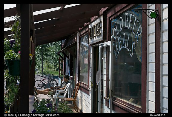 Man sitting in front of McCarthy lodge. McCarthy, Alaska, USA (color)