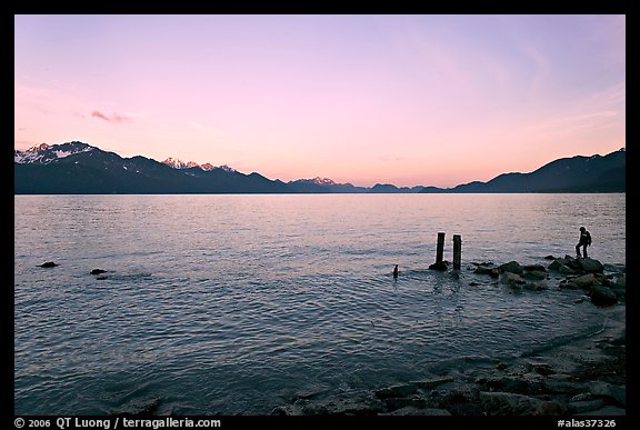 Boy standing in front of Resurrection Bay, sunset. Seward, Alaska, USA (color)