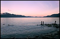 Boy standing in front of Resurrection Bay, sunset. Seward, Alaska, USA (color)