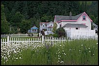 White picket fence and houses with pastel trims. Seward, Alaska, USA