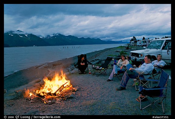 Sitting by campfire at midnight, waterfront campground. Seward, Alaska, USA