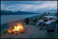 Sitting by campfire at midnight, waterfront campground. Seward, Alaska, USA