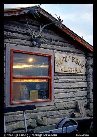 Log cabin with caribou antlers and sun reflected in window. Kotzebue, North Western Alaska, USA (color)