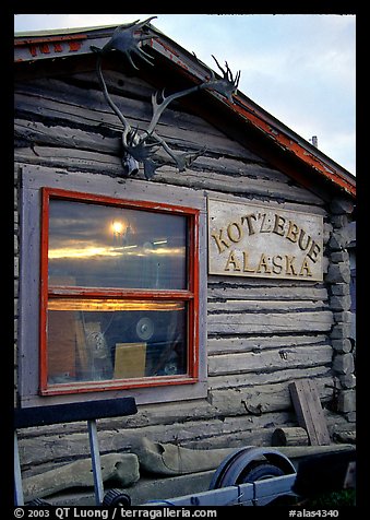 Log cabin with caribou antlers and sun reflected in window. Kotzebue, North Western Alaska, USA