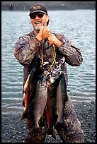 Man carrying salmon freshly caught in the Fishing Hole. Homer, Alaska, USA