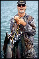 Fisherman carrying salmon freshly caught in the Fishing Hole. Homer, Alaska, USA (color)