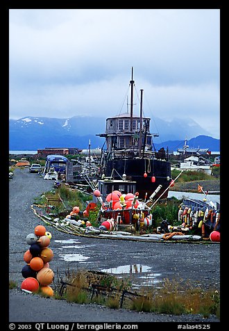 Retired fishing boat with a pile of marine gear on the Spit. Homer, Alaska, USA (color)