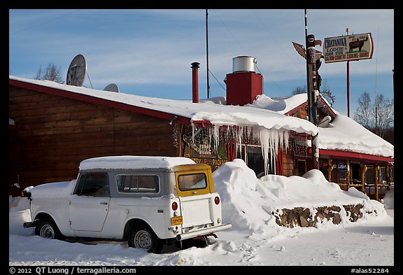 Old truck parked next to lodge in winter. Alaska, USA (color)