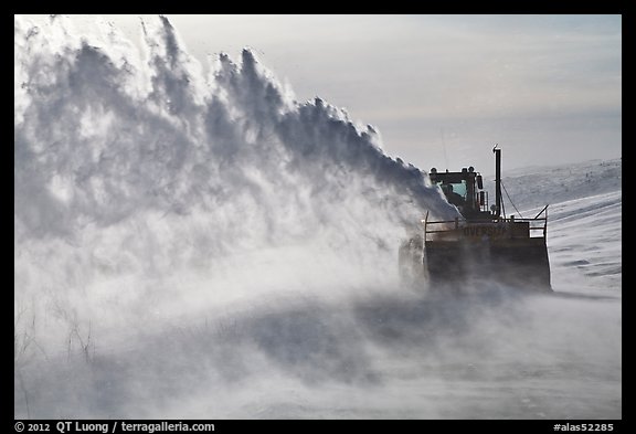 Winter service vehicle blowing snow out of road. Alaska, USA