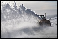 Winter service vehicle blowing snow out of road. Alaska, USA (color)