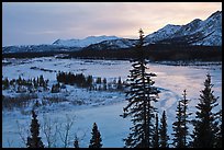 Winter landscape with frozen river at sunset. Alaska, USA