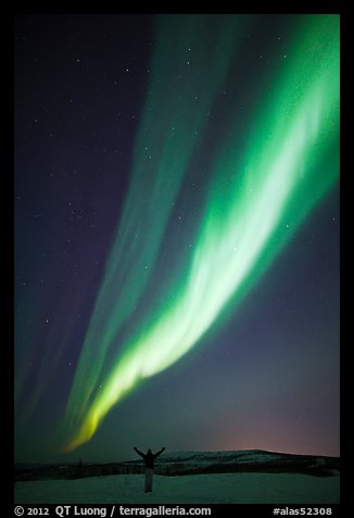 Aurora Borealis streaming above person with outstretched arms. Alaska, USA (color)