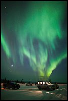 Northern Lights dance above snowy parking lot. Alaska, USA